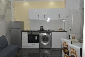 a kitchen with a stove and a washing machine at APART VERSAI in Varna City