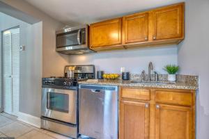 a kitchen with stainless steel appliances and wooden cabinets at Budget Bed Room near Downtown Inner Harbor w Free Parking in Baltimore