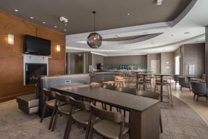 a restaurant with a table and chairs and a bar at SpringHill Suites by Marriott Charlotte Ballantyne in Charlotte