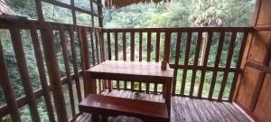 un banco de madera sentado en el porche de una cabaña en Ha Giang Faithien Homestay en Ha Giang