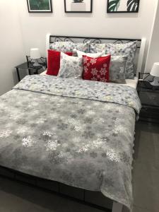 1 dormitorio con 1 cama grande con almohadas rojas en Apartament Studio Platan en Świnoujście