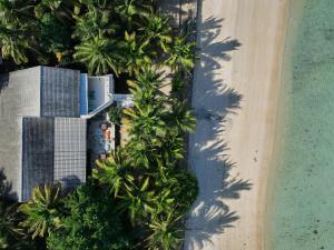 eine Luftansicht auf einen Strand mit Palmen und einem Gebäude in der Unterkunft Myamo Beach Lodge in Jereweh