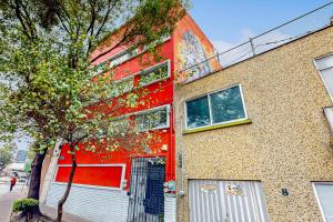 a red building with a tree in front of it at Cadetes 47 #201 in Mexico City