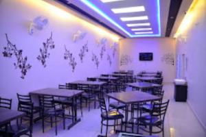 a room with tables and chairs in a restaurant at Hotel Golden Leaf , Sagar in Sāgar