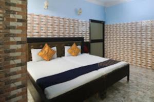 a bedroom with a bed with orange pillows at Hotel Maitry,Cuttack in Cuttack