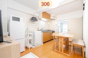 a kitchen and dining room with a table and a refrigerator at Downtown Apartment/ SHIBUYA Station 10mins on foot in Tokyo