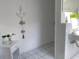 baño blanco con ducha y lavamanos en Am Kienbusch - Dachgeschoss, en Annweiler am Trifels