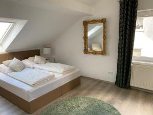 Dormitorio con cama con espejo y alfombra en Am Kienbusch - Dachgeschoss, en Annweiler am Trifels