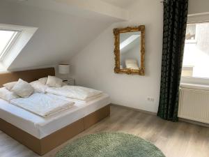 a bedroom with a bed with a mirror and a rug at Am Kienbusch - Südliche Weinstraße - Dachgeschoss in Annweiler am Trifels