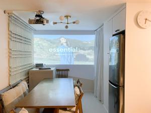 a dining room with a table and a kitchen at Stay Yeobaek,2BR,1BA - 2min to Hongdae, 5mins to Sangsu station in Seoul