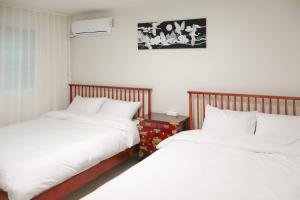 two beds sitting next to each other in a bedroom at Stay Yeobaek,2BR,1BA - 2min to Hongdae, 5mins to Sangsu station in Seoul