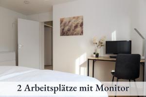 a bedroom with a bed and a desk with a computer at Relax-Apartment-One Ravensburg in Ravensburg
