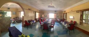 um restaurante com mesas e cadeiras num quarto em TAPHE GUEST RESORT em Naivasha