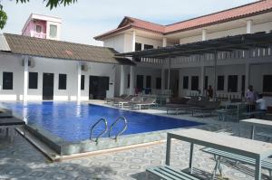 a swimming pool next to a building with a resort at Top One Backpacker Hostel in Vientiane