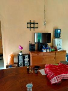 a living room with a tv and a wooden table at Roemah Sakinah in Ciguntur