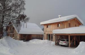 a snow covered house with a car parked next to it at Lichtzeit in Mauth