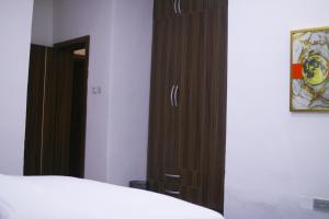 a bedroom with a wooden cabinet next to a bed at Victoria Homes - Lekki Apartment Lekki Phase 1 in Lekki +1 photo