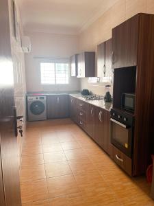 a kitchen with wooden cabinets and a stove top oven at Victoria Homes - Lekki Apartment Lekki Phase 1 in Lekki