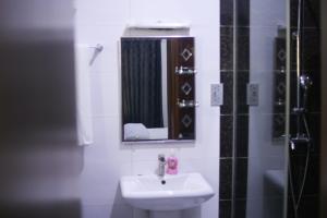 a bathroom with a sink and a mirror at Victoria Homes - Lekki Apartment Lekki Phase 1 in Lekki