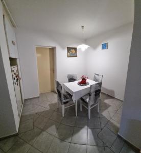 comedor con mesa blanca y sillas en Apartman 13 en Petrovaradin