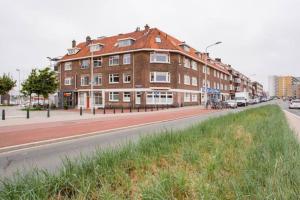 un gran edificio de ladrillo en el lateral de una calle en Stroll the waterfront from a Harbour-Site app, en La Haya