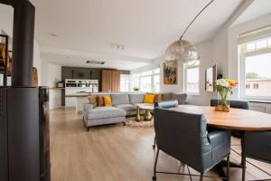 cocina y sala de estar con mesa y sofá en Stroll the waterfront from a Harbour-Site app, en La Haya