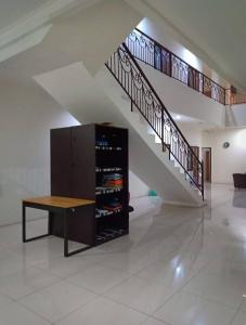 a staircase with a table and a cabinet with wine bottles at villa puncak tidar cece in Kasri