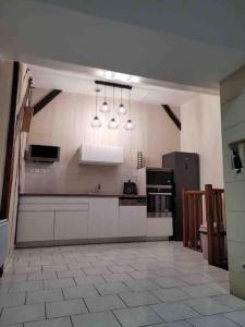 a large kitchen with white counters and appliances at Appartement calme et chaleureux in Tours
