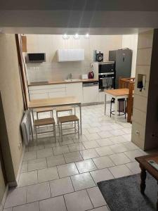 a kitchen with a table and some chairs and a counter at Appartement calme et chaleureux in Tours