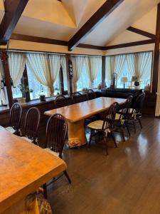 a large dining room with wooden tables and chairs at ALBERGO DEL PESCATORE in Minamiaizu