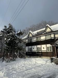une maison avec de la neige devant elle dans l'établissement ALBERGO DEL PESCATORE, à Minamiaizu