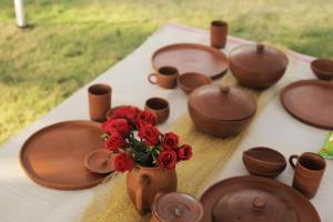 a table with a vase with red roses in it at Bastar Greens in Jagdalpur