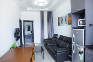 a living room with a black couch and a table at Rugando apartment one bedroom (Whatsapp only : +250788784988) in Kigali