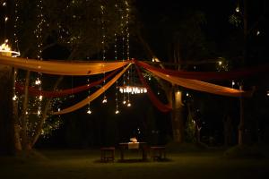 a tent with chandeliers and lights in the night at Bastar Greens in Jagdalpur