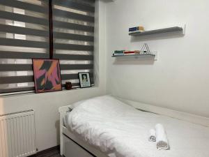 a white room with a bed and a window at Pejton's Hidden Gem: 94squares in City Center in Pristina
