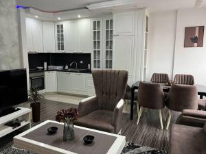 a living room with a table and a kitchen at Pejton's Hidden Gem: 94squares in City Center in Pristina