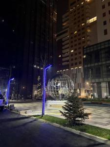 a large metal sphere in a city at night at Pejton's Hidden Gem: 94squares in City Center in Pristina