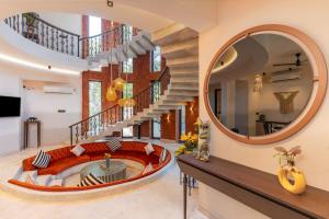 un gran espejo circular en una sala de estar con una escalera circular en Lotus Villa Goa en Mandrem
