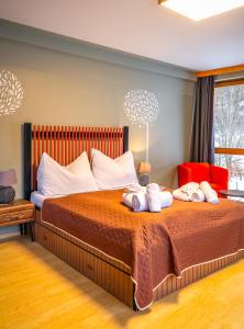 a bedroom with a bed with two stuffed animals on it at Kinderhotel Appelhof in Mürzsteg