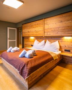 a bedroom with a large bed with two stuffed animals on it at Kinderhotel Appelhof in Mürzsteg