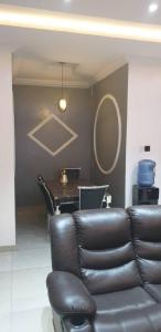 a living room with a leather couch and a table at Gradun in Ikeja