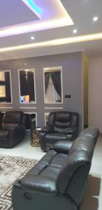 a living room with a leather couch and chairs at Gradun in Ikeja