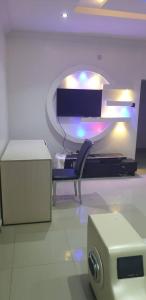 a room with a tv and a chair and a box at Gradun in Ikeja