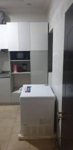 a kitchen with white cabinets and a white refrigerator at Gradun in Ikeja