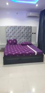 a bedroom with a purple bed with a purple bedspread at Gradun in Ikeja