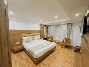 une chambre d'hôtel avec un lit et une télévision dans l'établissement Hotel Lee Green- best family hotel in Darjeeling, à Darjeeling