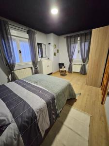 ein Schlafzimmer mit einem Bett in einem Zimmer mit Fenstern in der Unterkunft Casita con encanto in Collanzo