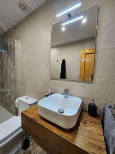 y baño con lavabo, aseo y espejo. en Casita con encanto, en Collanzo