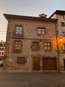 un antiguo edificio de ladrillo con puertas y ventanas en Casa los 8 caños, en Ezcaray