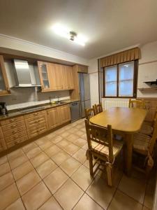 una cocina con mesa de madera y sillas. en Casa los 8 caños, en Ezcaray